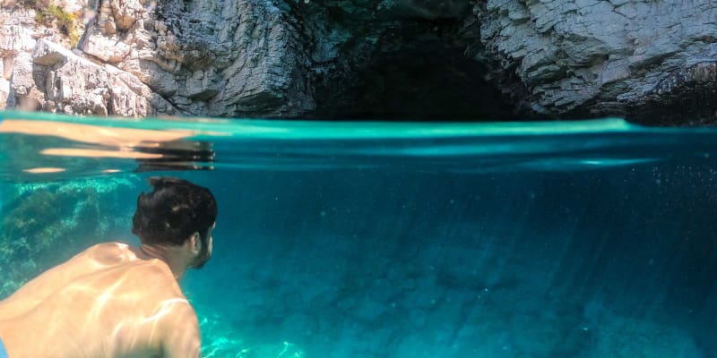 Man swimming outside the Blue Lagoon in Corfu, Greece